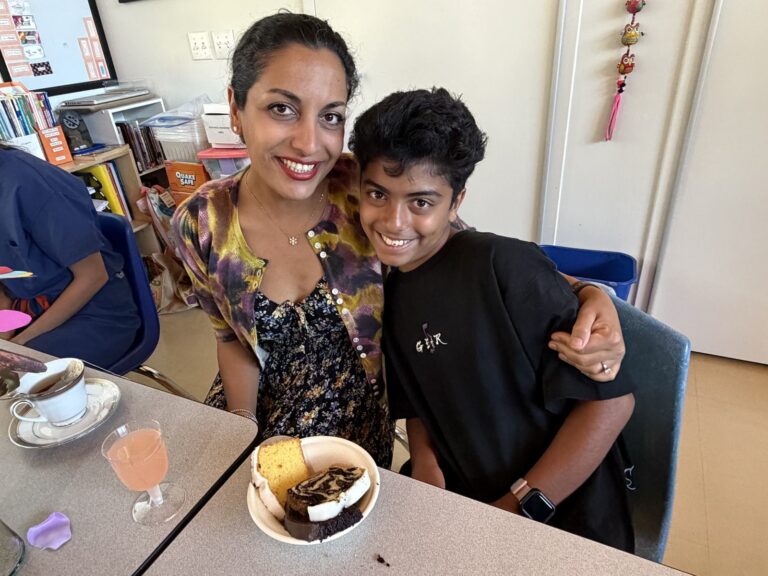 Mother and son sharing a hug over tea and pastries at Mothers' Night