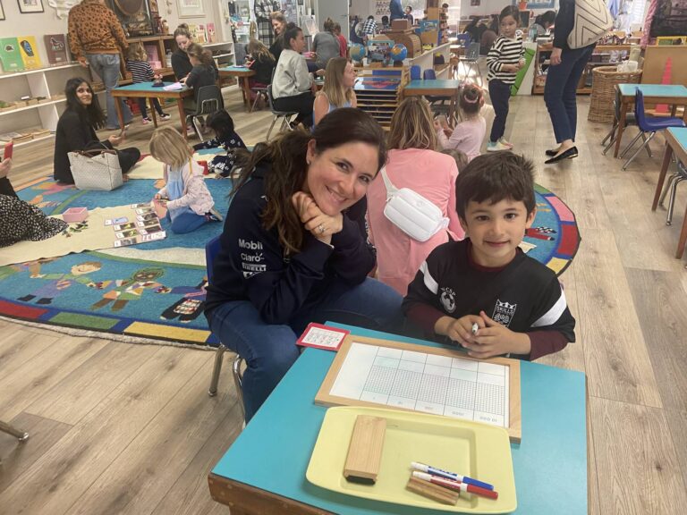 Mother and son working with Montessori materials at a classroom table during Mothers' Night
