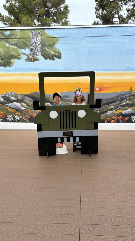 Two young campers smiling from the CMS jeep photo booth during safari week