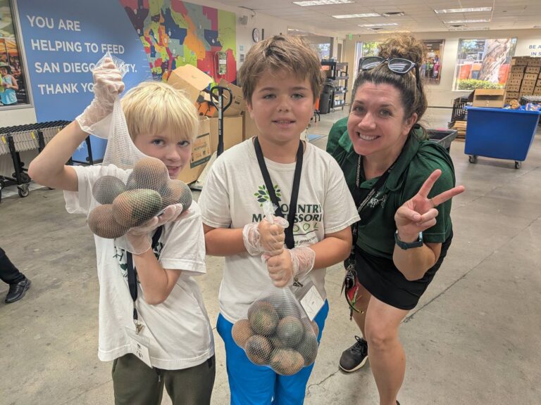 Students and a teacher holding up bags of sorted avocados at the Feeding San Diego distribution center
