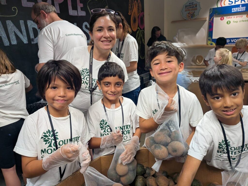 Country Montessori students in volunteer shirts holding bags of produce at Feeding San Diego